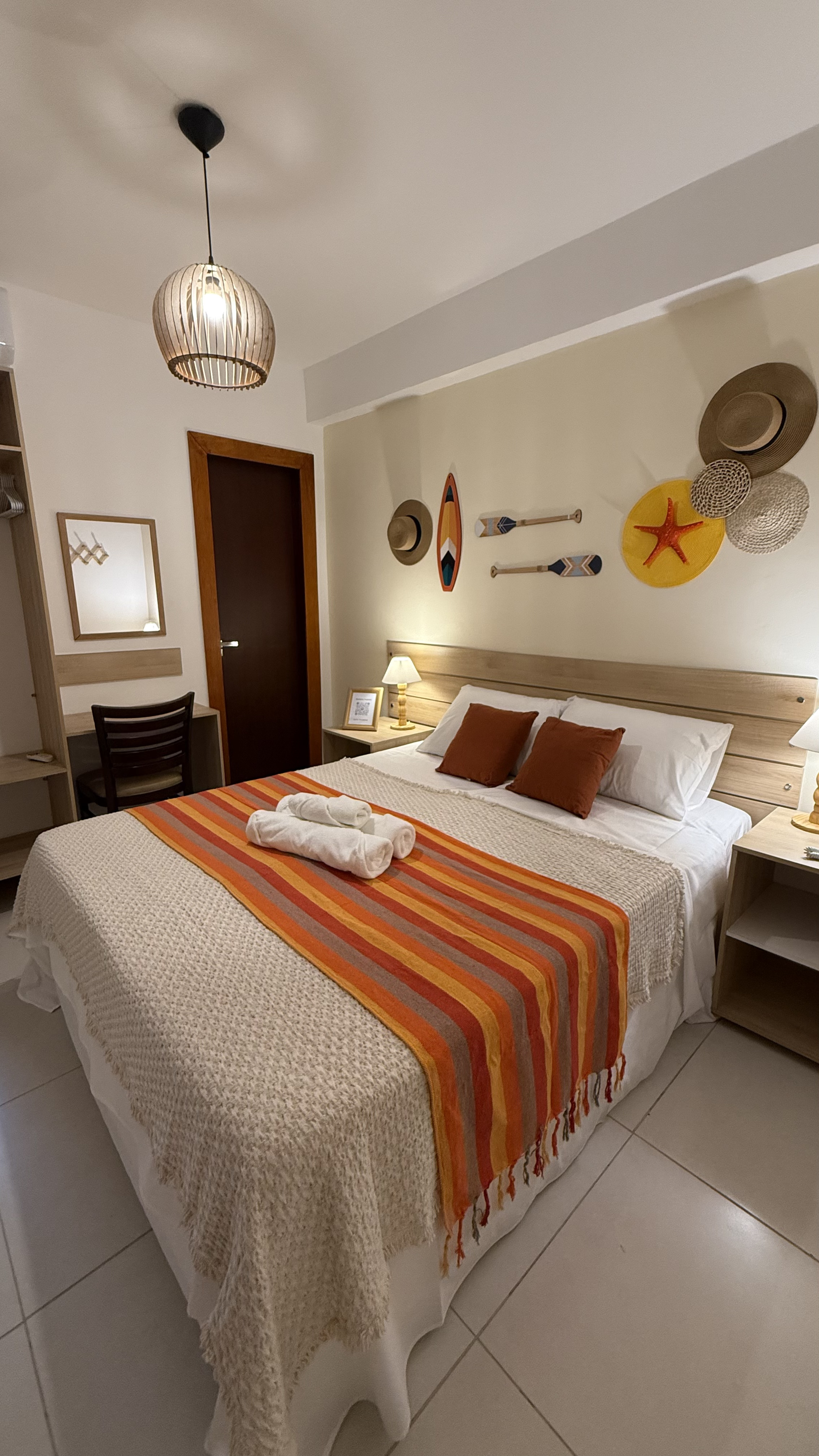 Quarto duplo da Pousada Mar da Vila com cama de casal, decoração náutica e manta listrada