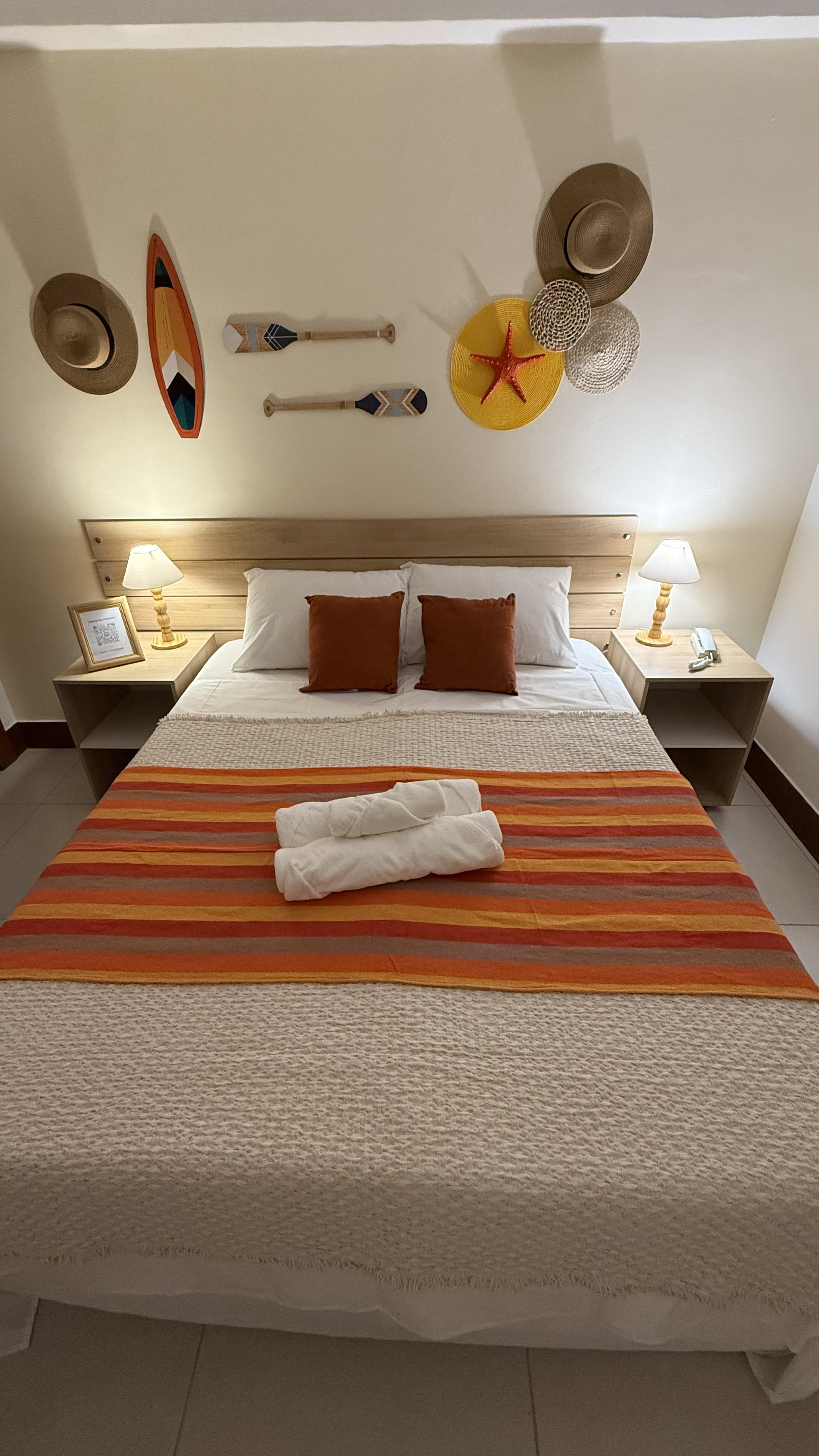 Cama de casal arrumada com toalhas dobradas e almofadas